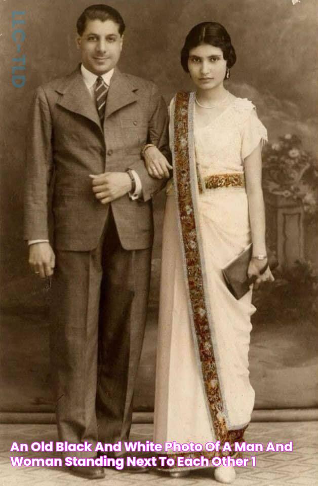 an old black and white photo of a man and woman standing next to each other