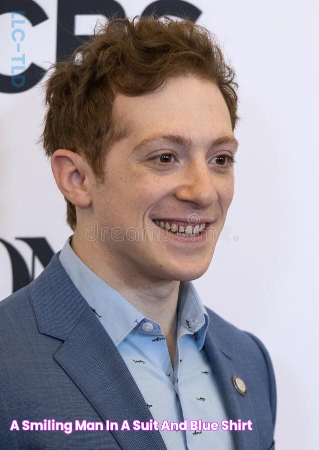 a smiling man in a suit and blue shirt